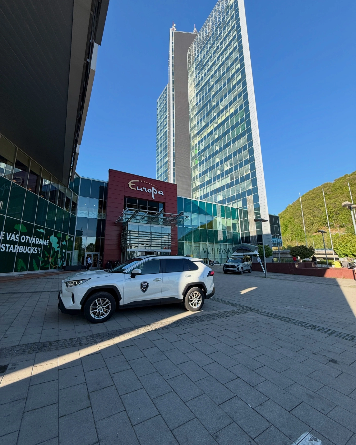 LEST TAXI white Toyota sedan parked at Europa Shopping Center parking area